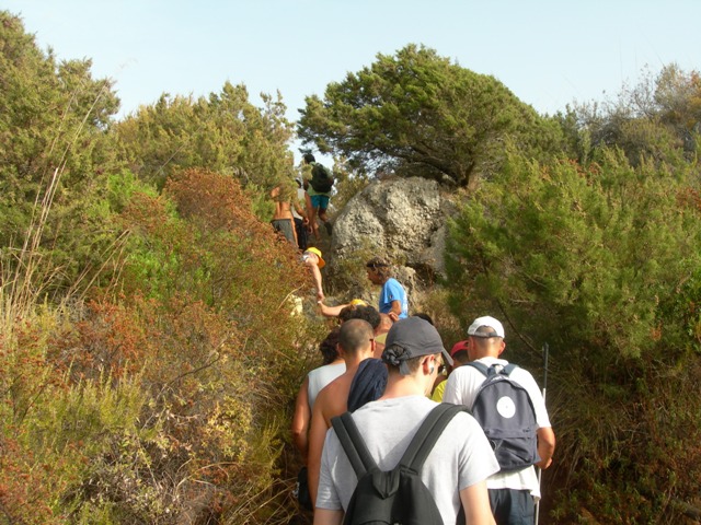 Il gruppo impegnato in un passaggio difficoltoso tra le rocce e la vegetazione.